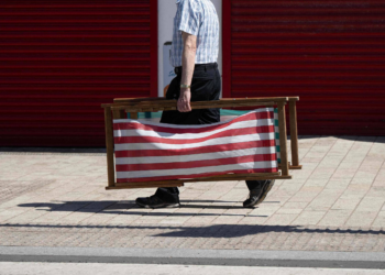 Um homem correndo com uma cadeira na mão